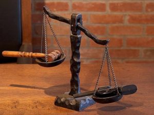 scale of justice weighing judge's gavel and a gun
